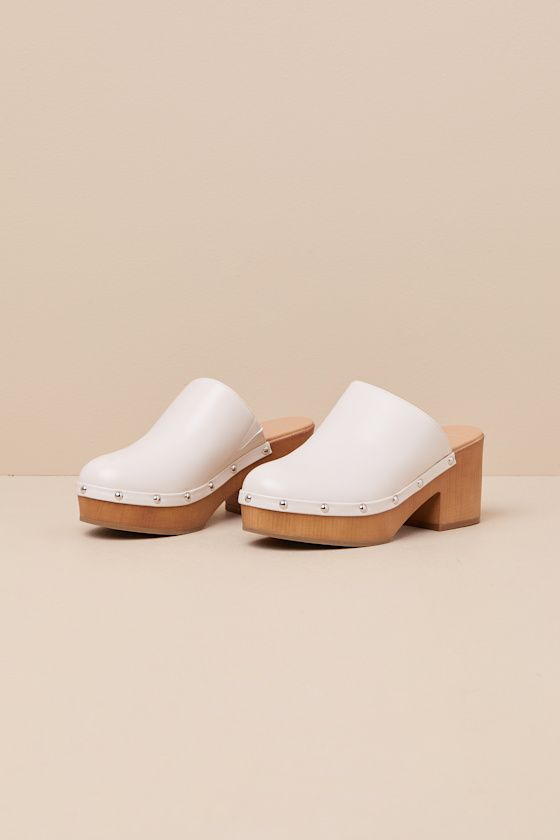 Step into the cutest style of the season with the Lulus Romain Bone Studded Platform Clogs! These wardrobe-essential clogs have a smooth, faux leather construction that shapes a rounded toe and a classic curved topline with an elastic gusset at the instep. Silver mirrored studs lends a hint of shine along the wood-look heel that carries into a 1"" toe platform. 3" wood-look block heel. Smooth insole. Rubber sole has nonskid markings. Man made materials. Imported. Lulus | Romain Bone Studded Plat Synthetic Clogs With Stacked Heel And Open Heel, Spring Synthetic Clogs With Stacked Heel, Synthetic Clogs With Stacked Open Heel, Synthetic Open Heel Clogs With Stacked Heel, White Clogs With Removable Insole And Block Heel, Summer Clogs With Contrasting Heel Counter And Round Toe, Spring Clogs With Contrasting Heel Counter And Round Toe, Spring Clogs With Contrasting Heel And Round Toe, Spring Clogs With Reinforced Block Heel