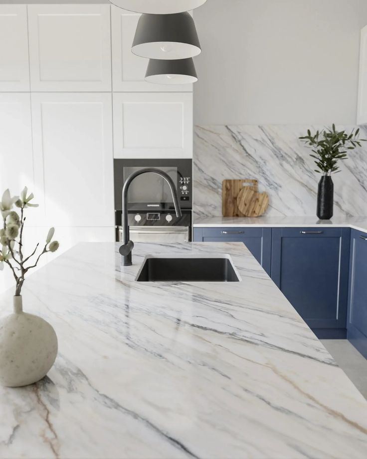 a kitchen with marble counter tops and blue cabinets