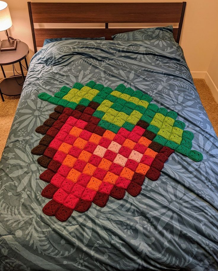 a bed with a blanket made to look like an apple on the top and bottom