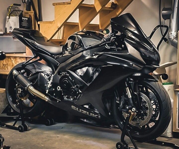 a black motorcycle parked inside of a garage