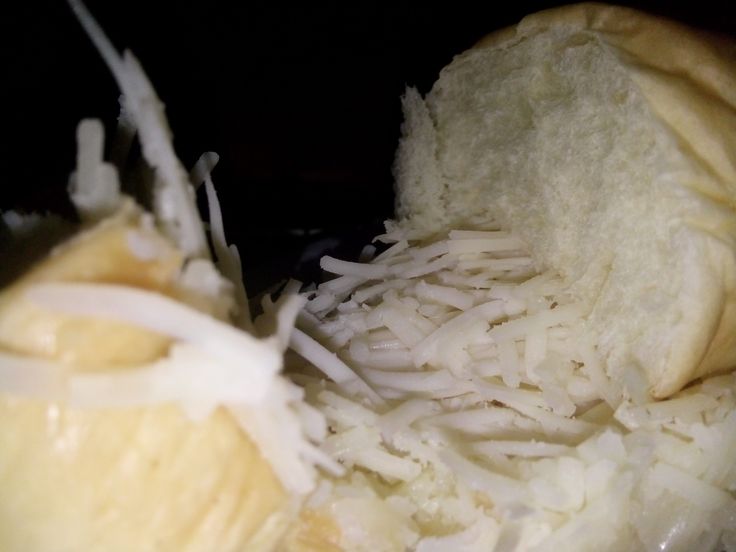 a sandwich with cheese and onions is shown in close up view from the inside out