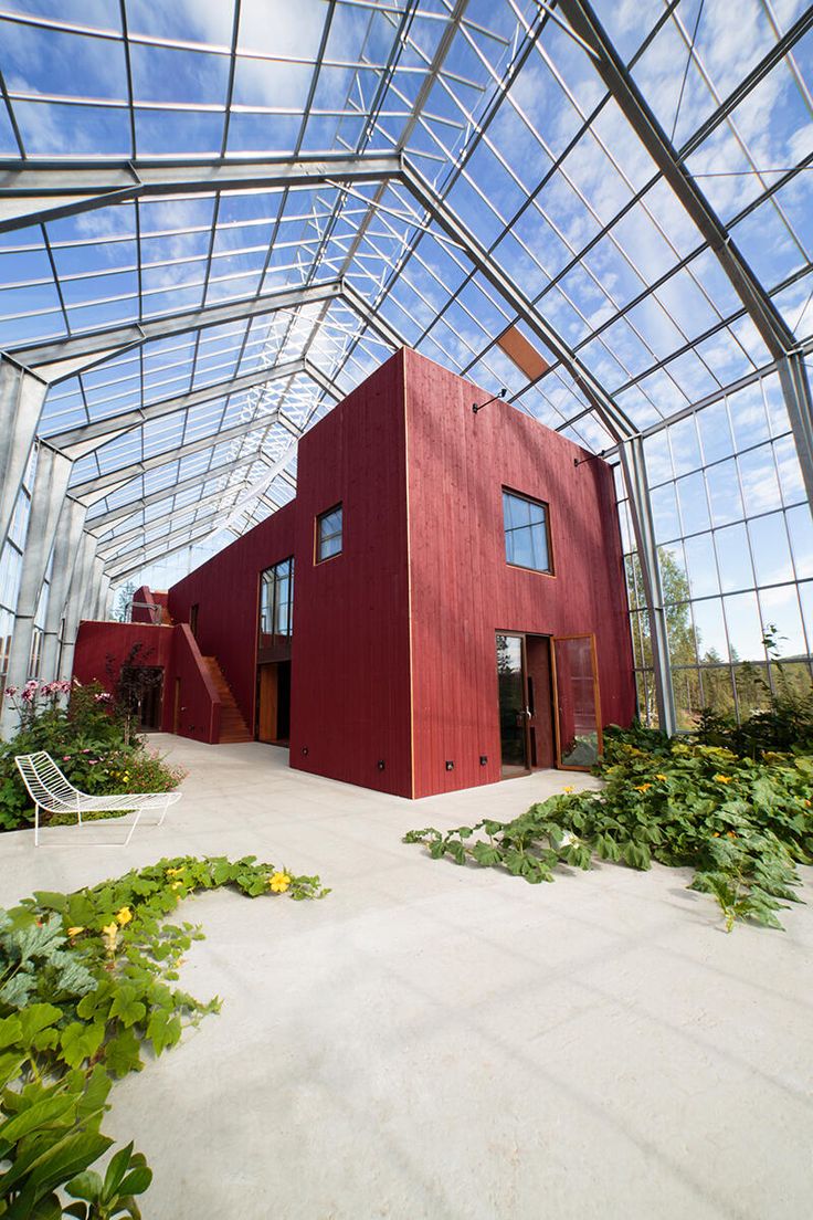 a red building with lots of windows and plants