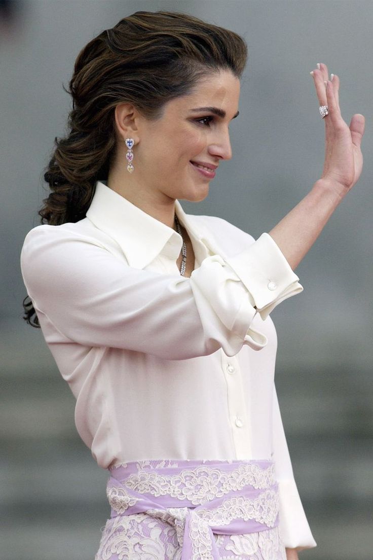 a woman in a pink dress waves to the crowd