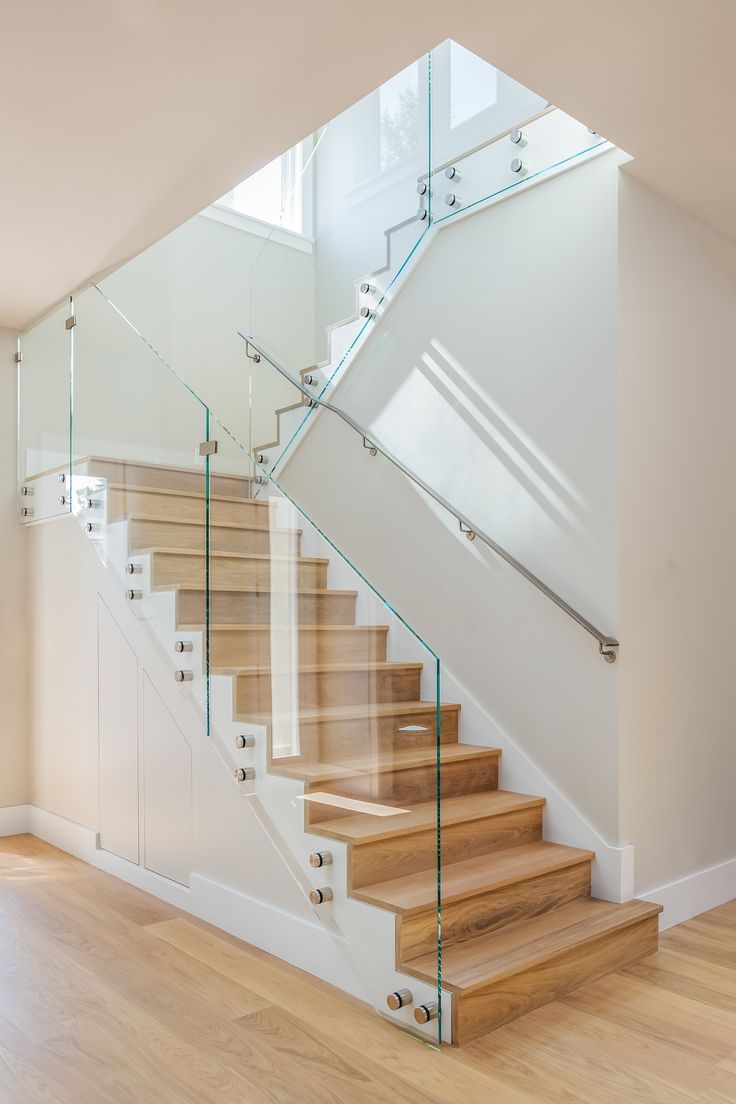 a staircase with glass railing and wooden steps