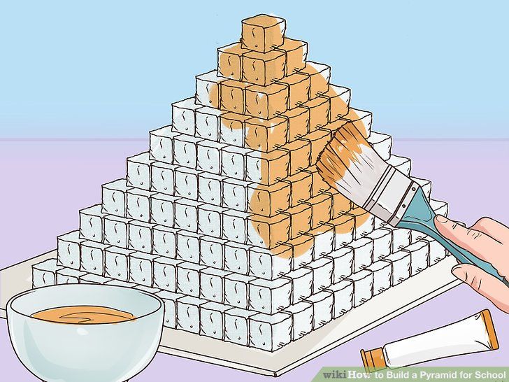 a person is painting the top of a pyramid