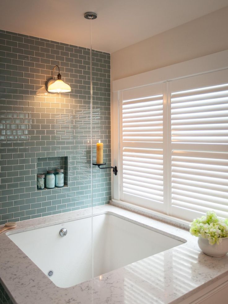 a bath tub sitting next to a window in a bathroom