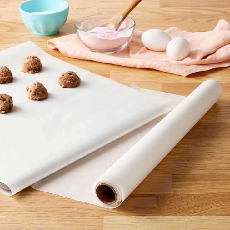 doughnuts are laid out on top of a paper towel and next to a bowl of eggs