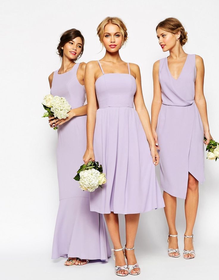 three bridesmaids in lavender dresses holding bouquets and posing for the camera with white flowers