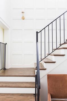 a chair sitting on top of a wooden floor next to a set of stairs