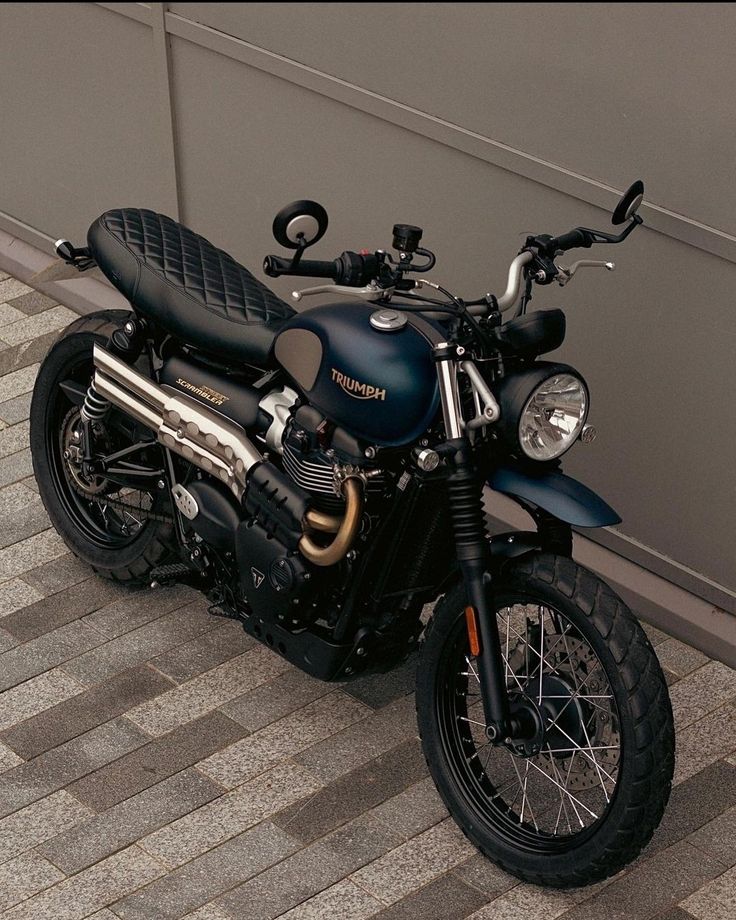 a black motorcycle parked next to a wall