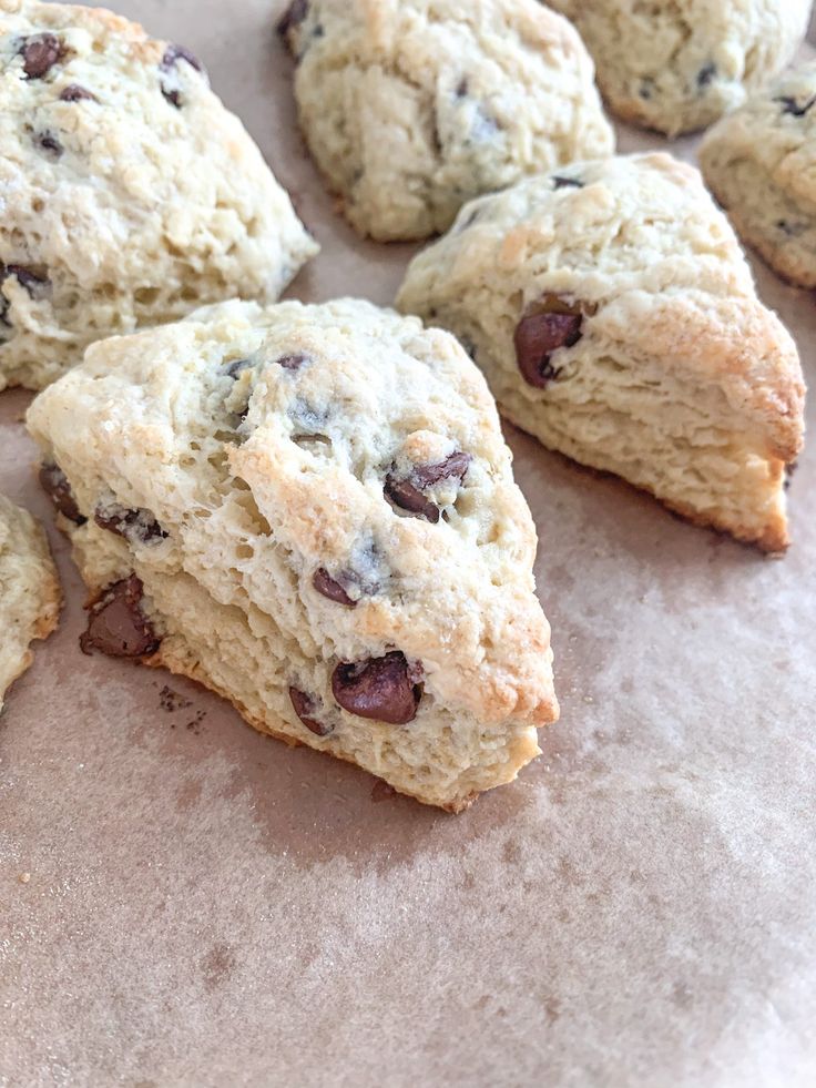 several scones with chocolate chips on top of parchment paper