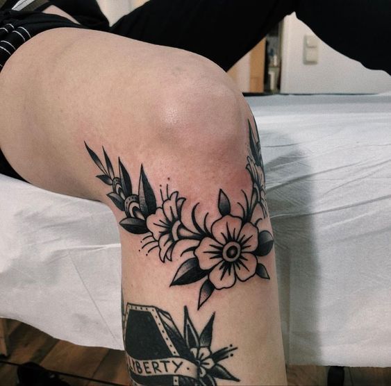 a woman's leg with flowers on it and the word pretty written in black ink