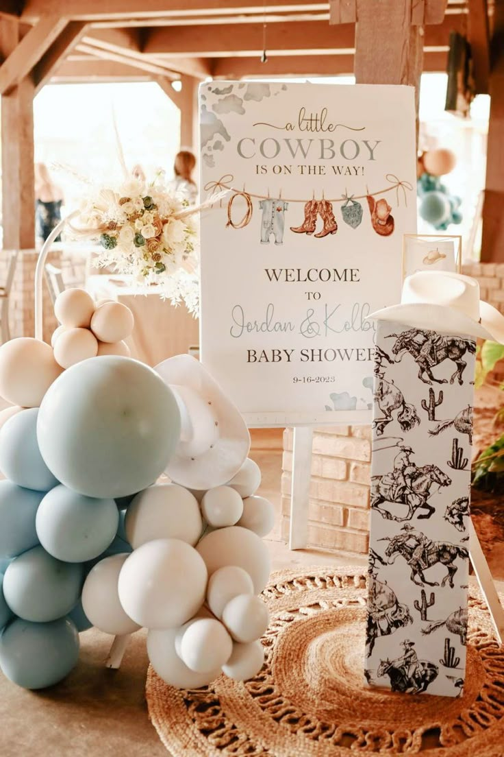 baby shower decorations and welcome sign on display at a baby shower in the barn with balloons