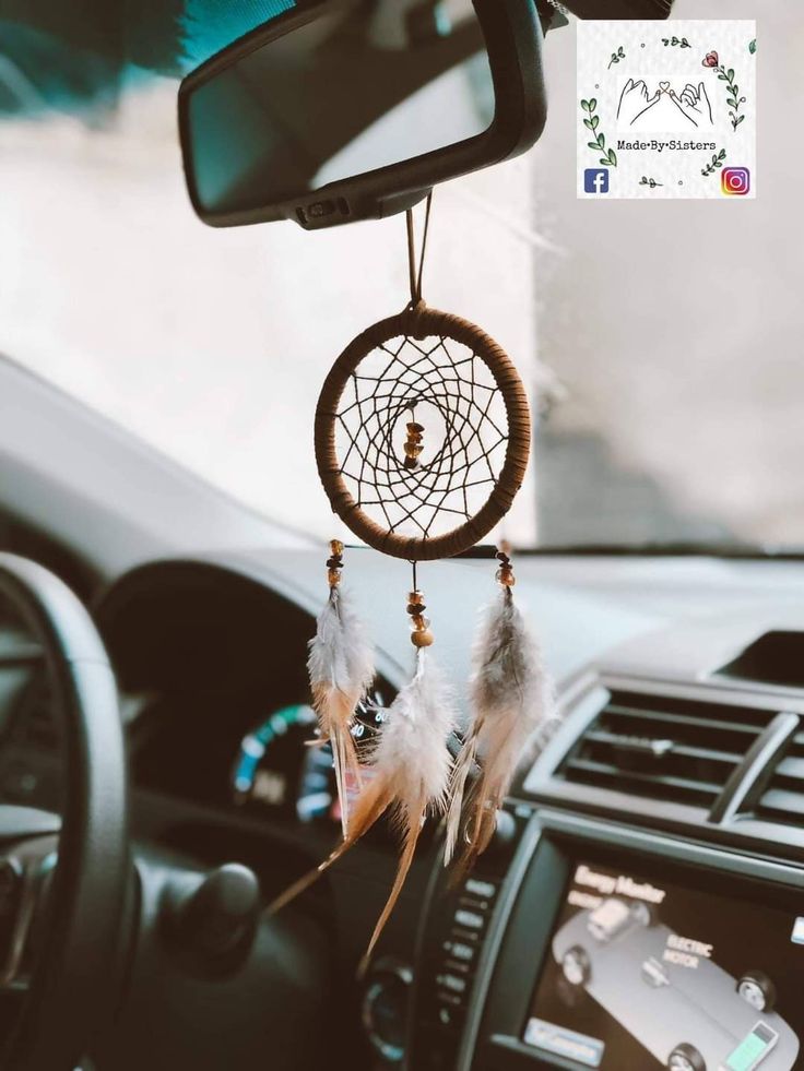 a car dashboard with a dream catcher hanging from the dash