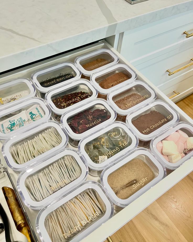 an organized drawer is shown with spices and pastasticks in plastic containers on the drawers