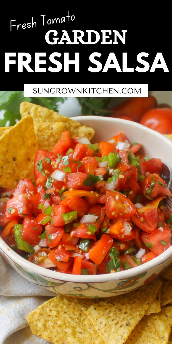 a white bowl filled with fresh salsa surrounded by tortilla chips and tomatoes on the side