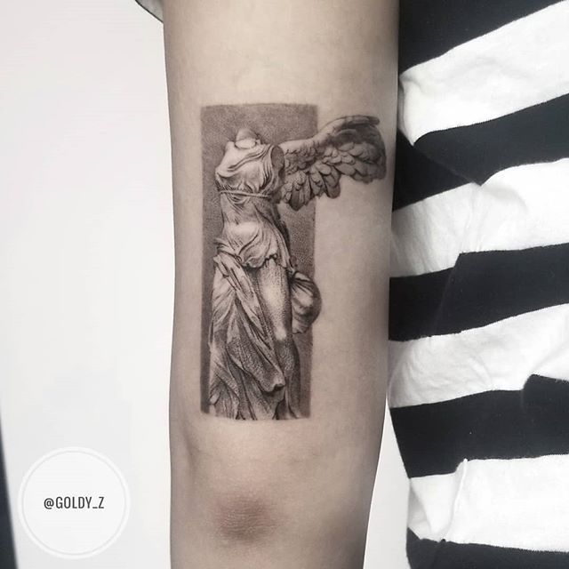 a woman's arm with a tattoo on it that has an image of the statue of liberty