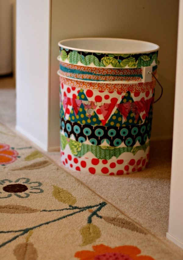 a colorful bucket sitting on the floor next to a door