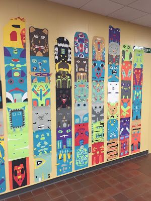 a wall covered in lots of colorful skateboards on top of a brick floor next to a yellow wall