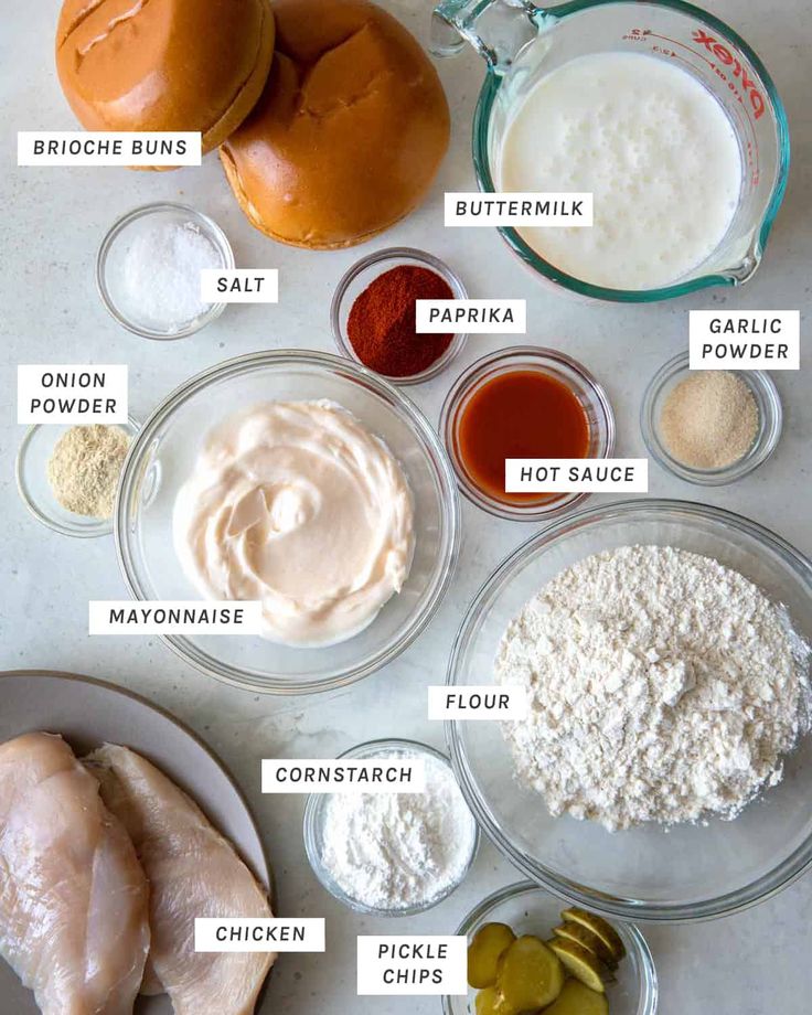 the ingredients to make chicken burgers laid out on a table