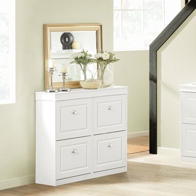 a white dresser with flowers on top in a room