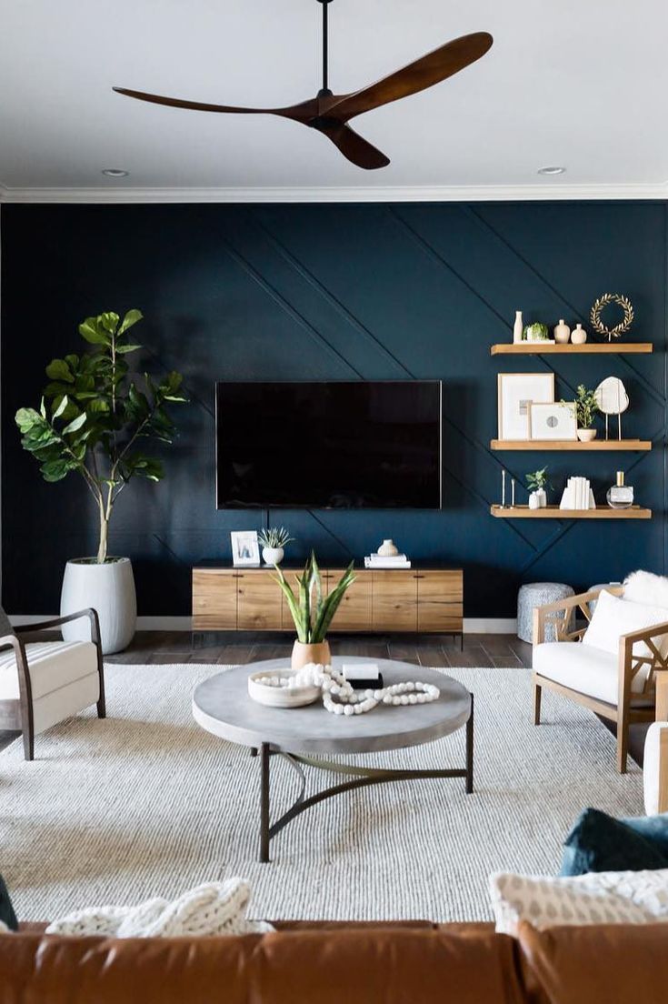 a living room filled with furniture and a flat screen tv mounted on a wall above a coffee table