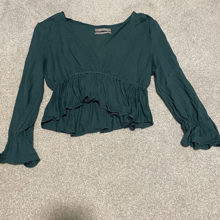 Cropped Dark Green Urban Outfitters Peplum Top. Super Cute And Comfy. Peplum Also On The Sleeves. Deep V Neck And Long Sleeves. Never Worn And Great Condition. Price Negotiable. Last Picture Is The Picture On The Model And The Second Photo Shows The Color The Best. No Rips Of Flaws. Size Medium. Bohemian V-neck Top With Ruffle Hem, Green V-neck Top With Ruffles, Spring Long Sleeve Tops With Ruffle Hem, Flowy V-neck Top With Ruffles, Green Long Sleeve Rayon Top, Spring Long Sleeve Peplum Top With Ruffle Hem, Green Rayon Long Sleeve Tops, Spring Long Sleeve Peasant Top With Ruffle Hem, Long Sleeve Ruffle Peplum Top For Brunch