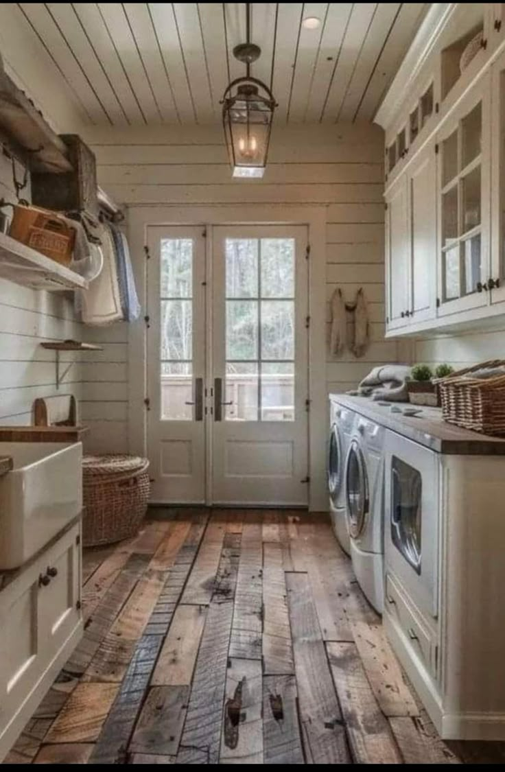 a white washer and dryer in a room with wood flooring on the walls