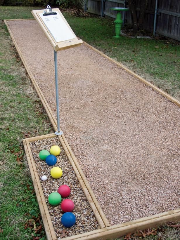 an outdoor play area with balls in the ground and a marker board on top of it