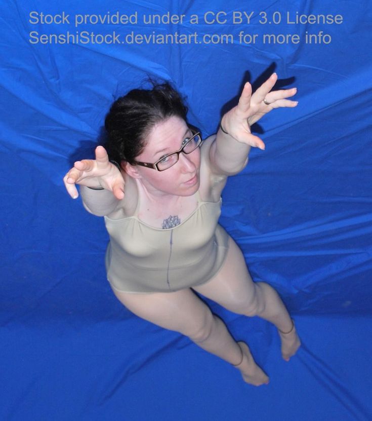 a woman floating in the water with her hands up