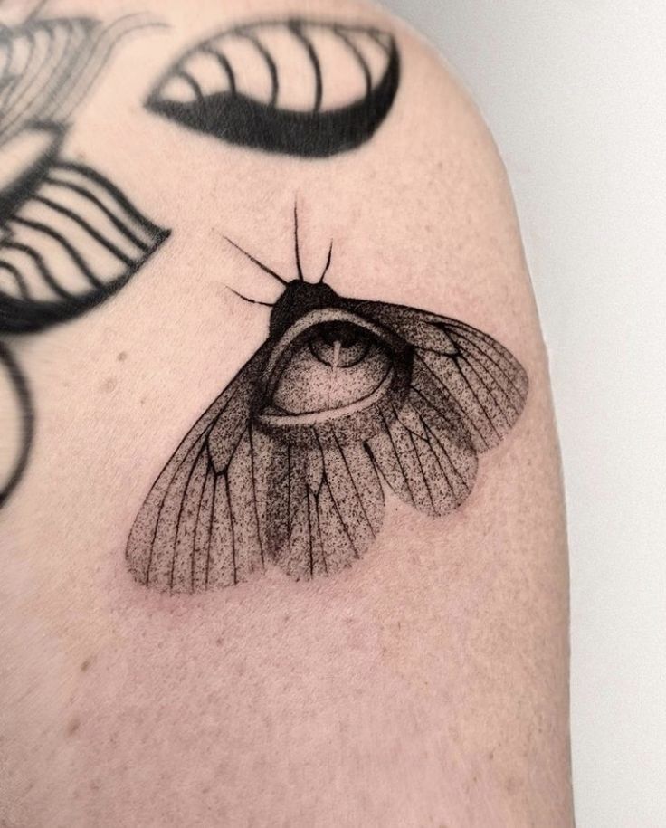 a close up of a person's arm with a tattoo on it and an eye