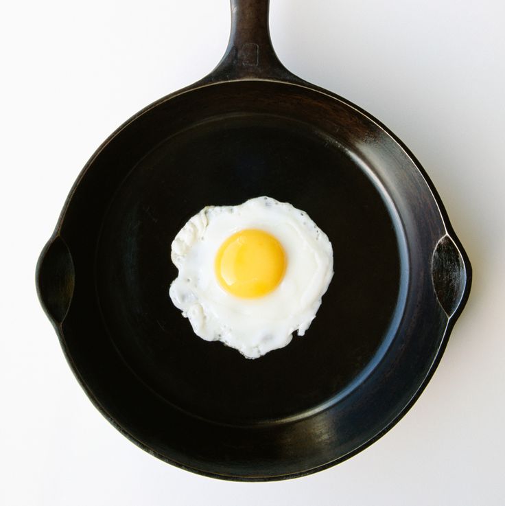 an egg in a frying pan on a white table