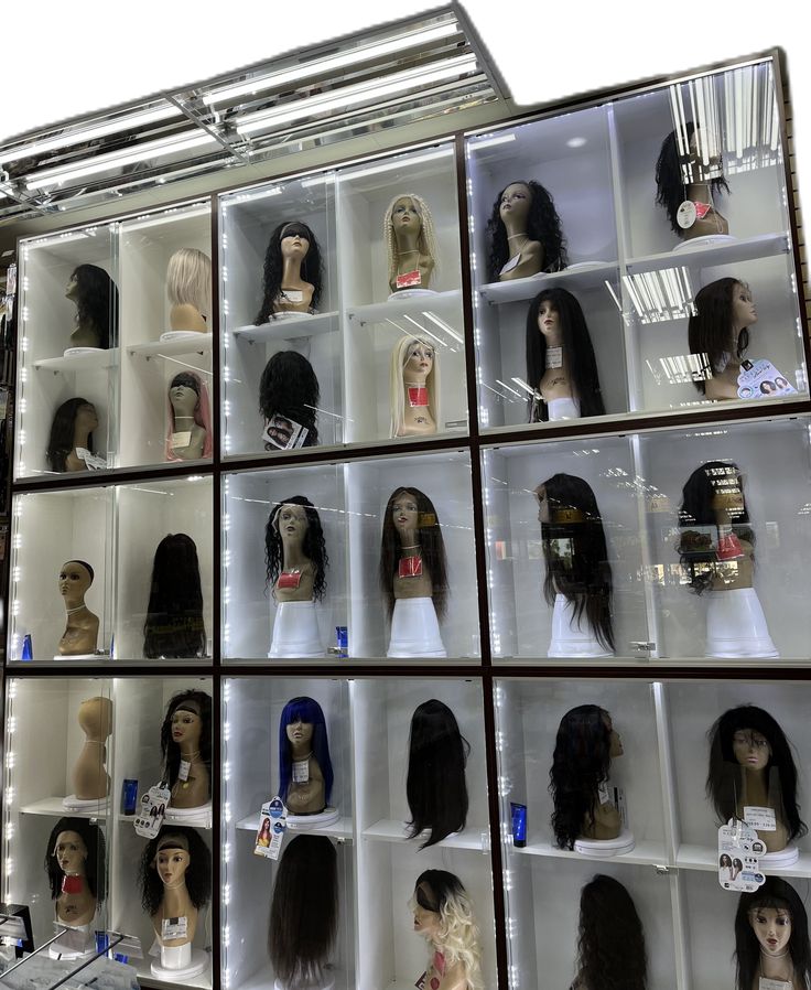 several rows of wigs are on display in a case