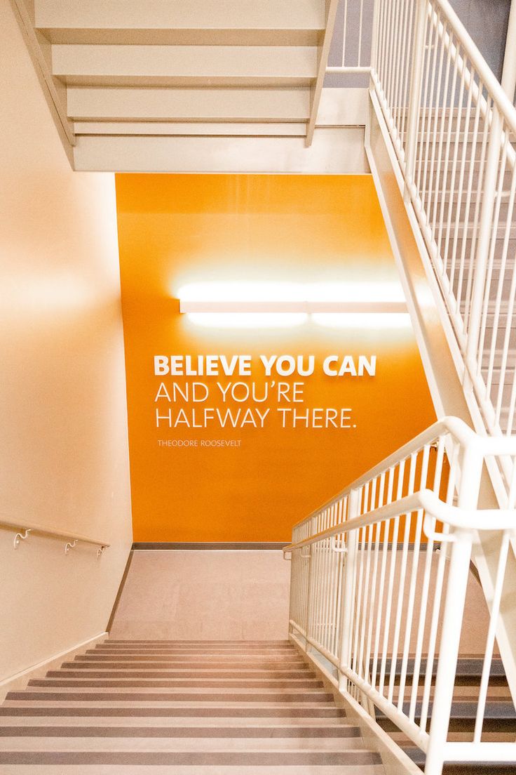 an orange and white sign on the side of a building that says, believe you can and you're halfway there