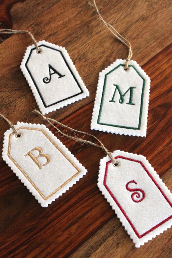 three tags with the letters m, b, and c hanging from twine strings