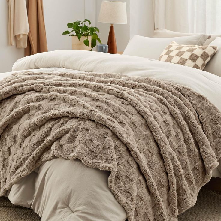 a bed covered in a blanket and pillows