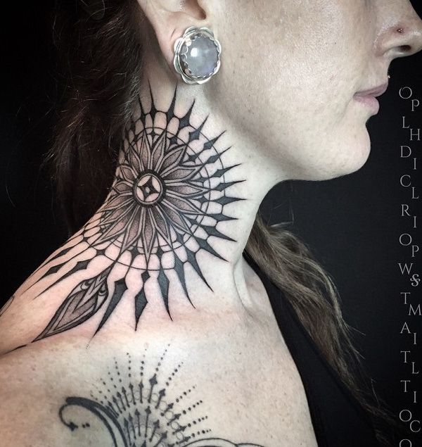 a woman's neck with a sun and feather tattoo on it