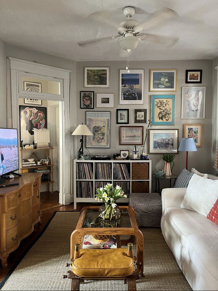 a living room filled with lots of furniture and pictures on the wall above it's coffee table