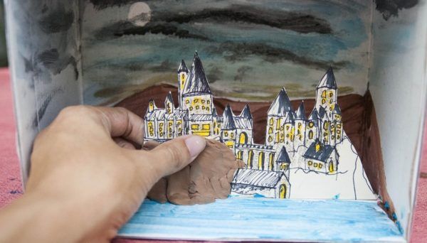 someone is drawing a castle with colored pencils