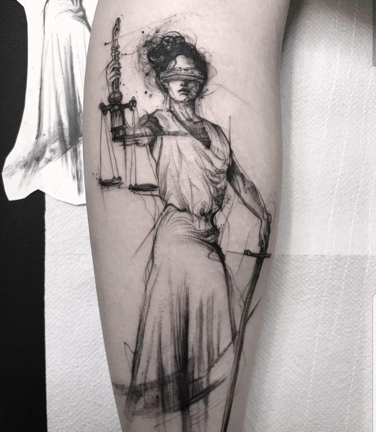 a lady justice tattoo on the left thigh and right leg with an arrow in her hand