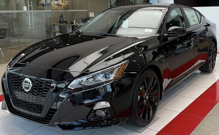 a black and red car is on display in a showroom