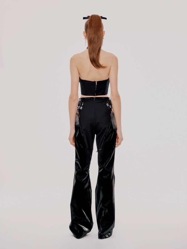 An edgy addition to every wardrobe. These chic pants feature a form-flatting high waist, patent leather paneling, and cut-outs with buckles on the side. It's all in the details. Patent Leather Paneling Cut-out On Sides Buckle Details High waisted fit SIZE & FIT Model is wearing a size M Model is 5'10 & 110lbs FABRIC Side A: Base 100% Viscose Coating 100% Polyurethane Side B: 80% Polyester 20% Viscose Lining: 100% Polyester