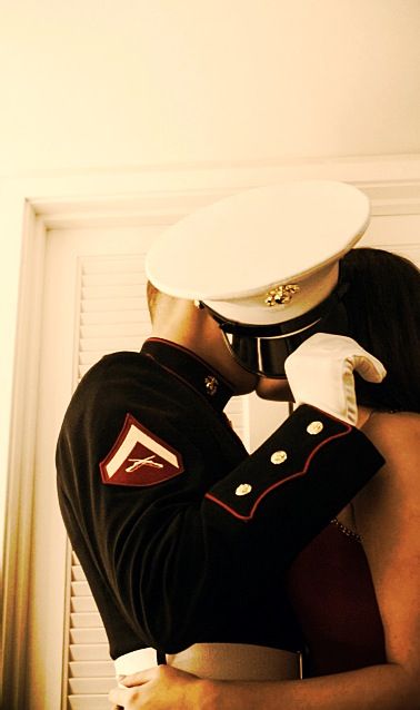 a man and woman hugging each other in front of a window with white shutters