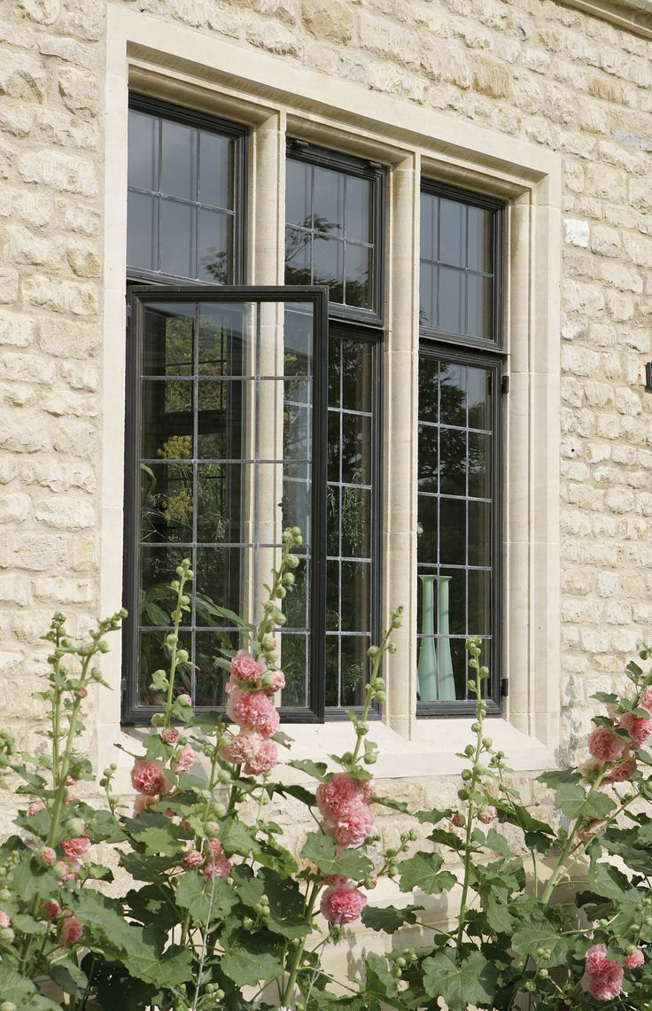 the window is open and there are pink flowers in front of it