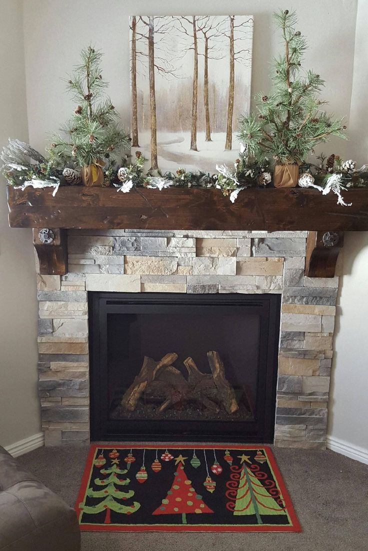 a fireplace with christmas decorations on the mantle