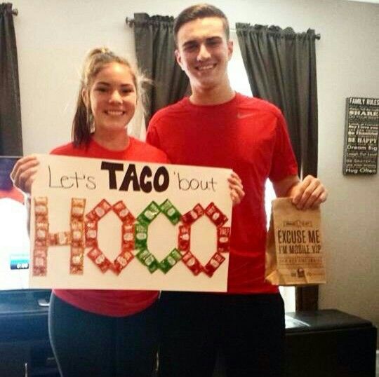 two people holding up a sign that says let's taco bout hoo