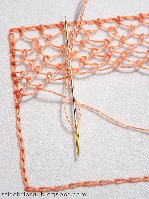 an orange crochet stitch being worked on by a pair of scissors and thread