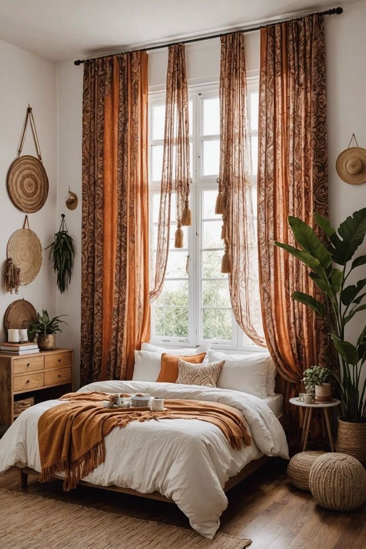 a bed sitting under a window in a bedroom next to a wooden dresser and potted plant