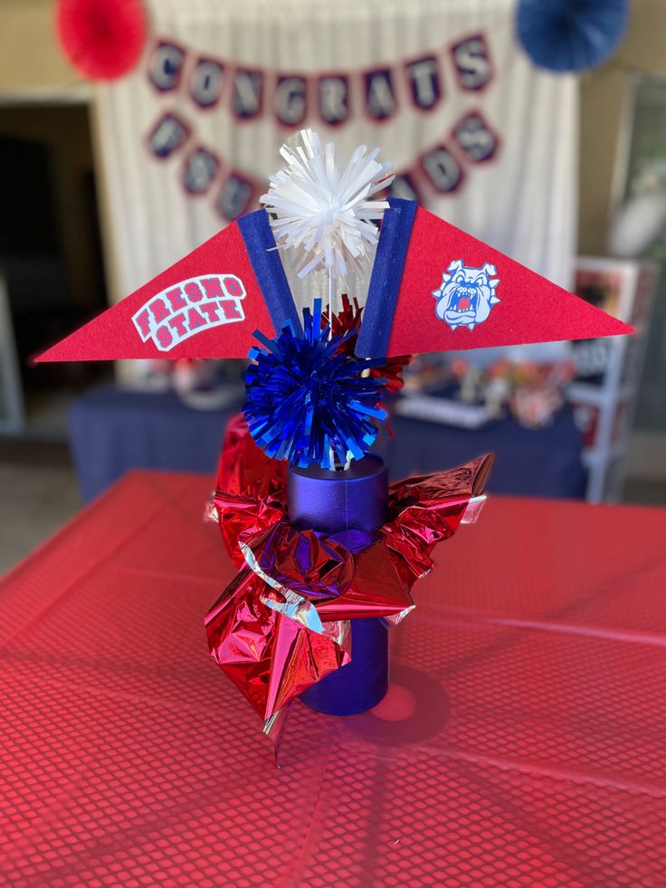 a red, white and blue pinwheel on top of a table with decorations in the background