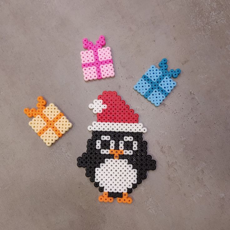 the penguin is wearing a santa hat and has three pieces of perler bead